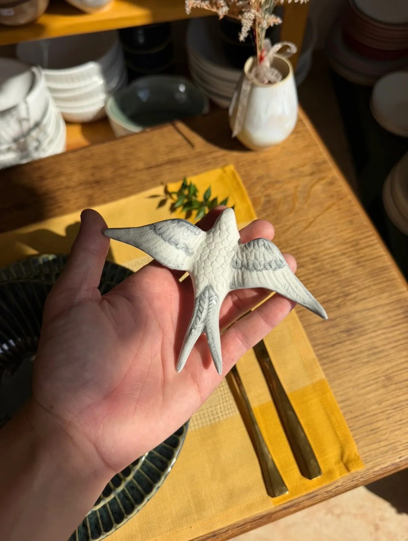 Figura de golondrina de cerámica en la mano